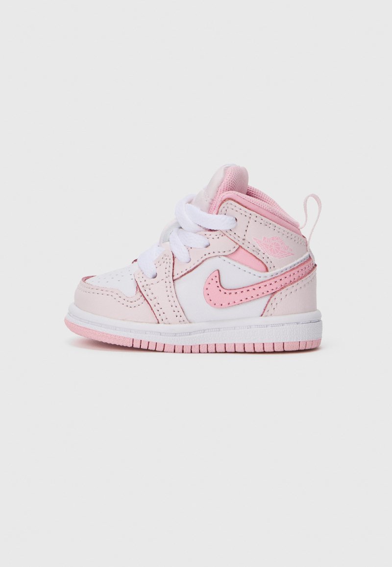 Białe i różowe trampki Nike Air Jordan w rozmiarze dziecięcym z białymi sznurówkami i różową podeszwą na jednolitym jasnym tle.