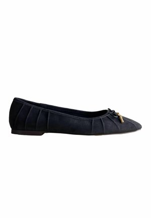 Black flat ballet shoe with pleated sides and a small bow with gold-tone charm on the front.