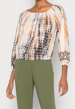 Bunte Bluse mit orangefarbenem, schwarzem und weißem Batikmuster. Verfügt über einen gerafften Ausschnitt, Knopfverschluss und bestickte Ärmelabschlüsse.