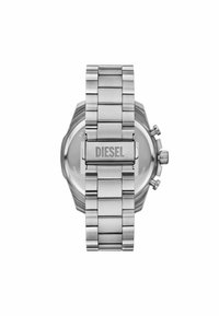 Silverfärgad klocka i rostfritt stål med en texturerad rem och lås. Varumärket "DIESEL" är graverat på låset. Rund klockkapsel med synliga tryckknappar.