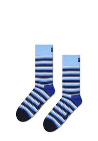 Chaussettes rayées en coton ; rayures bleu clair et foncé avec des accents marine. Présentent des bords côtelés et un renforcement au niveau des orteils et du talon.