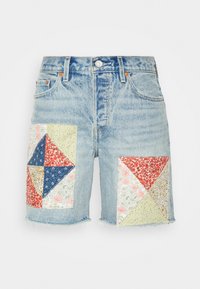 Light blue denim shorts with multicolored patchwork pockets featuring floral and geometric patterns. Frayed hem, classic five-pocket design.
