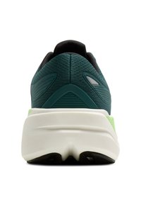 Bežecká obuv v tmavo modrej farbe s textúrovanou tkaninou, vypolstrovaným čiernym golierom a bielou medzipodrážkou doplnenou o zelený klip na päte a čiernu podrážku.