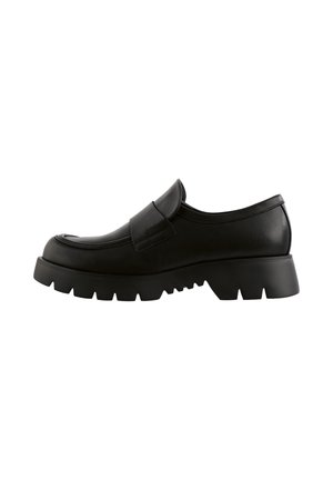 Black leather slip-on shoe with a rounded toe, padded vamp, and chunky rubber sole featuring a treaded pattern.