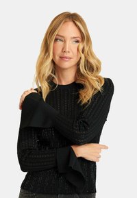 Czarny sweter z dzianiny z pionowymi paskami, teksturowanym ściągaczem i rozszerzanymi mankietami. Miękka tkanina o subtelnym połysku.