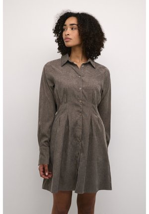 Robe boutonnée marron avec un col, des manches longues et des plis, fabriquée en tissu texturé. Présente des boutons marron sur le devant.