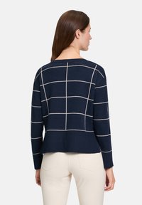 Marineblauer Pullover mit einem Rautenmuster aus leichterem Garn, mit langen Ärmeln, lockerer Passform und rundem Ausschnitt.