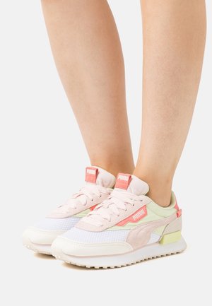 PUMA sneakers with a light pink, mesh upper, mint green accents, and white sole. Features laces, branding on the tongue, and textured details.