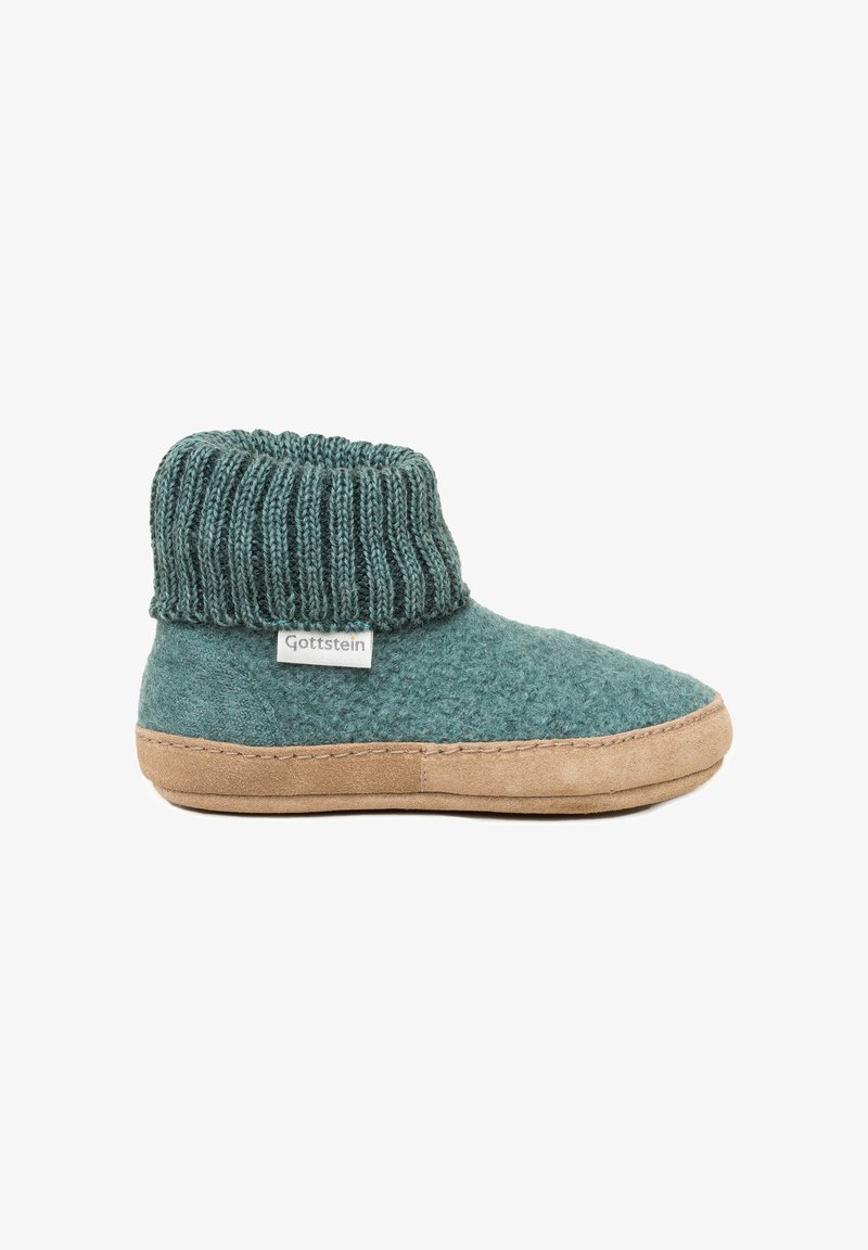 Pantofola di lana in teal con una cuffia a coste, suola in suede beige e dettagli cuciti. Etichetta del marchio sul lato. Design accogliente, alto alla caviglia.