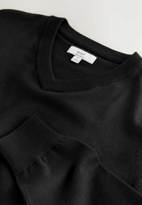 Pull noir à manches longues col en V avec poignets et encolure côtelés, taille moyenne, coupe régulière de la marque NEXT.