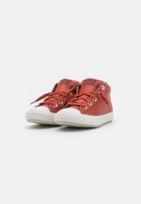 Czerwone sneakersy za kostkę z gładkiej skóry, biała gumowa podeszwa i sznurowany fason. Posiadają logo na języku oraz metalowe oczka.