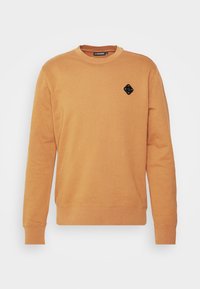 Oranžová mikina se širokým výstřihem, dlouhými rukávy a texturovanou černou diamatovou nášivkou na levé části hrudi. Hladký povrch látky.