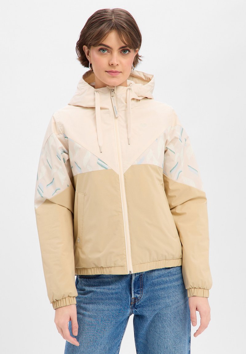 Veste à capuche beige zippée avec un design en blocs de couleur triangulaires, présentant des motifs d'accent clairs. Fabriquée en matériau lisse et léger.
