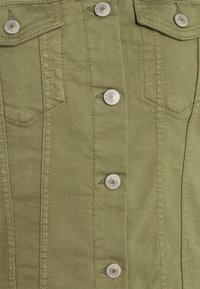 Olivgrön denimjacka med silverknappar, dubbla bröstfickor och sömdekorationer. Slät textur med en åtsittande design.