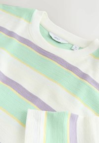 Pull col rond avec des rayures horizontales vert pastel, lavande, jaune et blanc, taille moyenne, étiquette « NEXT » visible à l'intérieur du col.