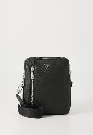 Sac à bandoulière en cuir noir avec finition texturée, quincaillerie en argent, fermeture éclair et bandoulière réglable avec logo tissé.