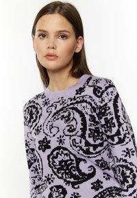 Lila sweter z kontrastowym czarnym wzorem paisley, okrągłym dekoltem i prążkowanymi mankietami, wykonany z miękkiego, teksturowanego materiału.
