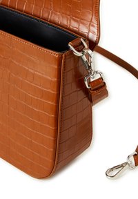 Borsa in finta pelle marrone con una finitura a pelle di coccodrillo, forma rettangolare, hardware argentato e tracolla regolabile. L'apertura superiore rivela un interno scuro.