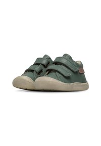 Chaussures en cuir vert avec deux bandes velcro, bouts ronds et semelle en caoutchouc beige dotée d'un motif de grip texturé.