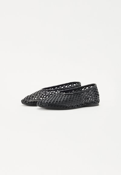 Black, lattice-patterned flats made of flexible material, featuring a rounded toe and low flat sole, designed for breathability.