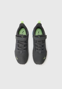 Chaussures de sport en mesh noir avec une surface texturée. Comprend une semelle intérieure verte, une sangle grise avec fermeture à boucle et des accents citron.