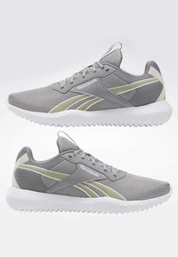 Paire de baskets Reebok grises avec semelles blanches et accents vert clair, vues de côté sur fond blanc.