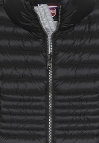 Schwarze Steppjacke mit hohem Kragen, ausgestattet mit gestepptem Textil, metallischem Reißverschluss und grauem Innenfutter. Markenetikett innen sichtbar.