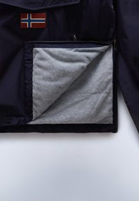 Navy jacket featuring a Norwegian flag patch; interior lined with soft grey fabric; includes a zippered pocket for storage.