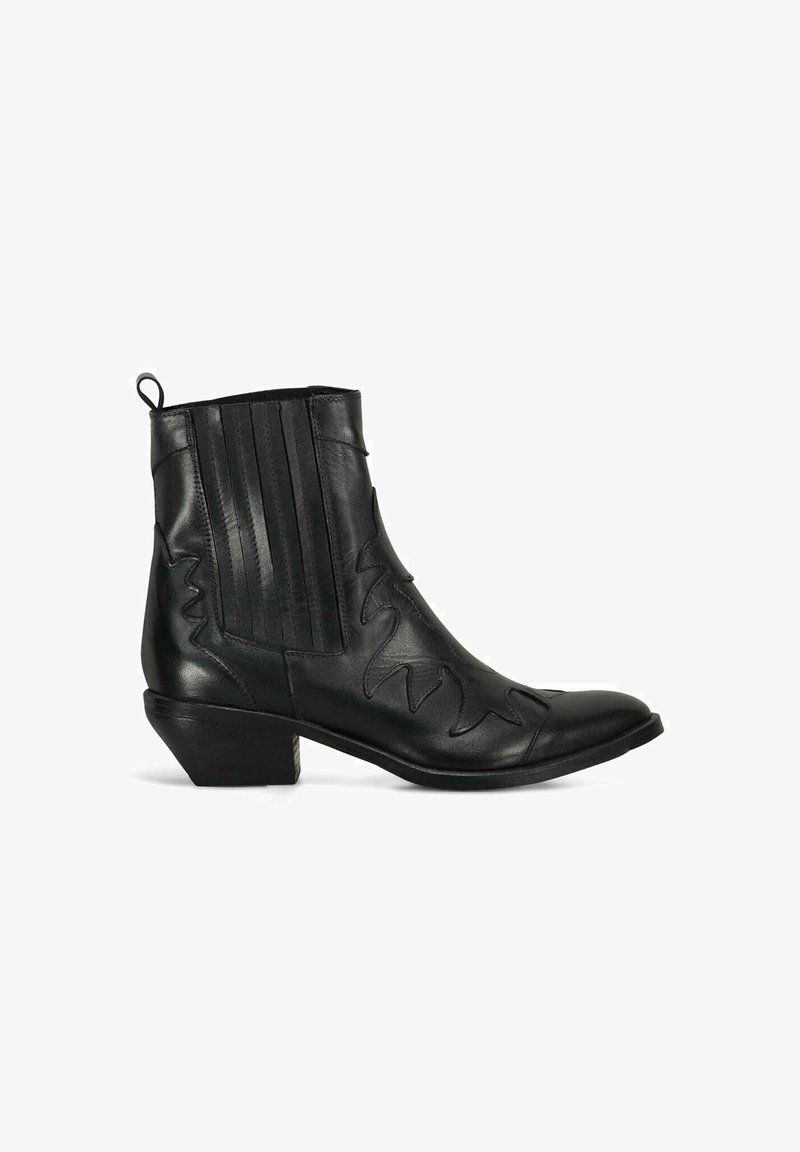 Bottine en cuir noir avec bout pointu, détails cousus, panneaux latéraux élastiques et un petit talon empilé. Texture lisse, design minimaliste.