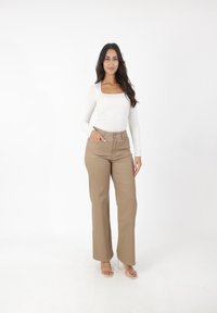 Witte top met lange mouwen en een vierkante halslijn, gecombineerd met hoogtaille beige wijde broek. Gladde textuur, casual pasvorm, subtiel ontwerp.