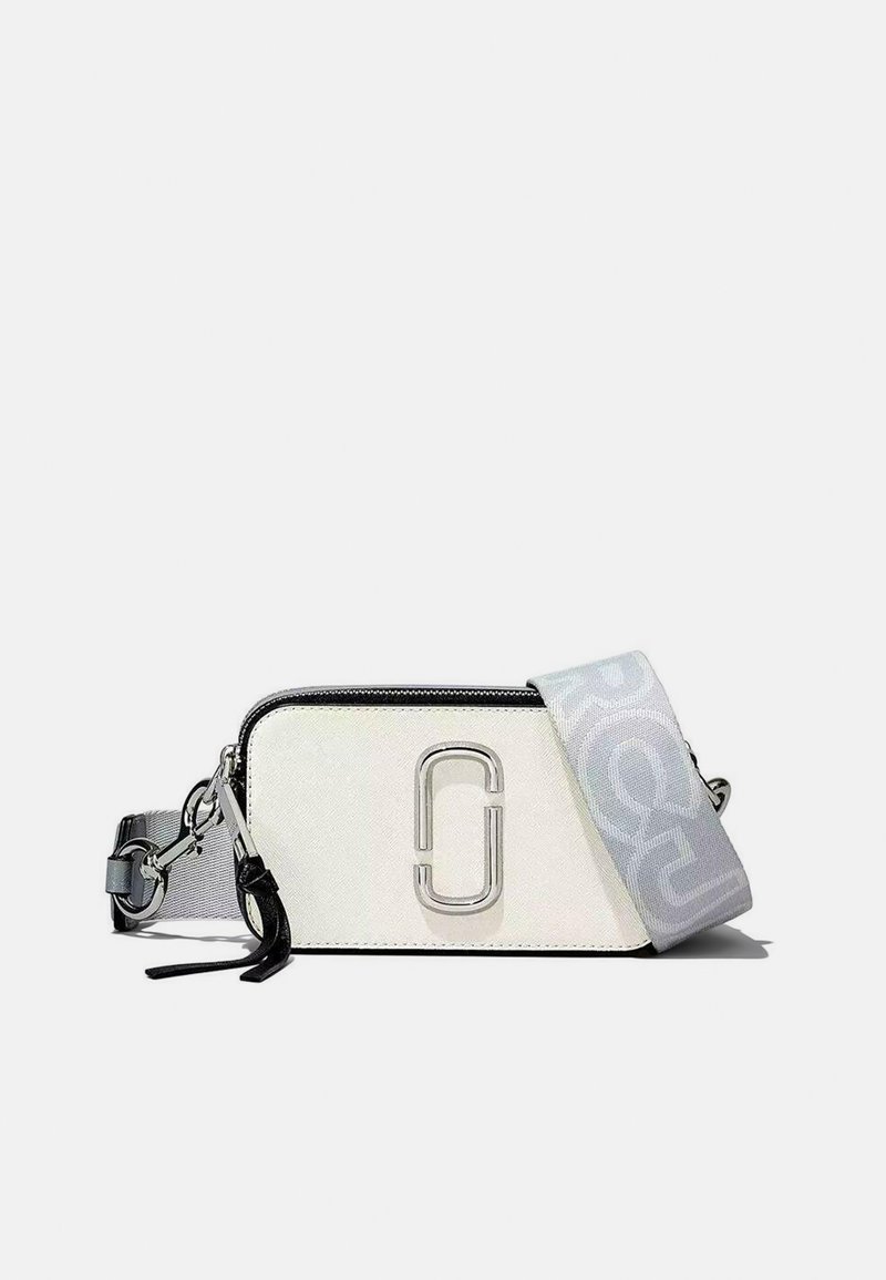 Borsa di stoffa bianca con un logo argento, zip nera e tracolla grigia con un motivo ripetuto. Forma rettangolare compatta.