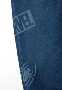 Blauwe denim jeans met een subtiel ontwerp, voorzien van het 'Marvel' logo en een spinnengrafiek in een lichtere tint.