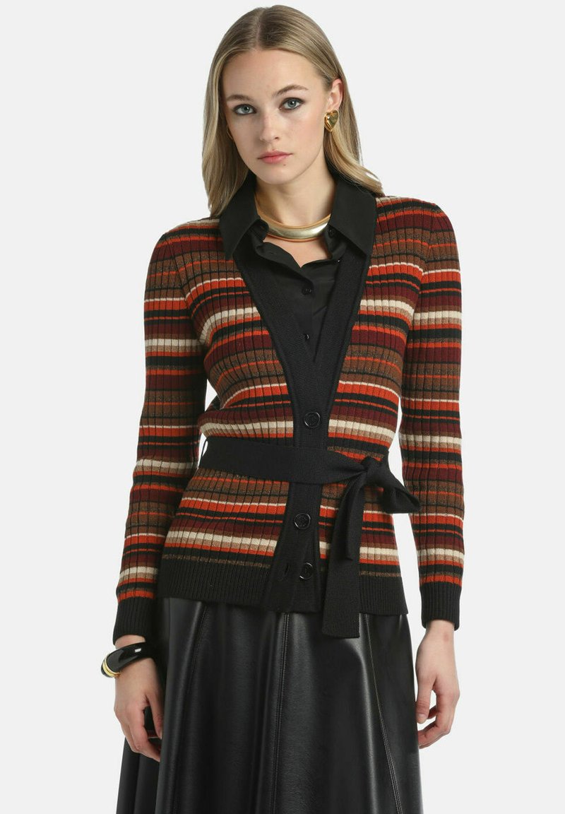 Cardigan raiat cu textură ribbed în nuanțe de roșu, portocaliu, maro și crem. Prezintă un guler tip șal negru, nasturi și un talie legată.