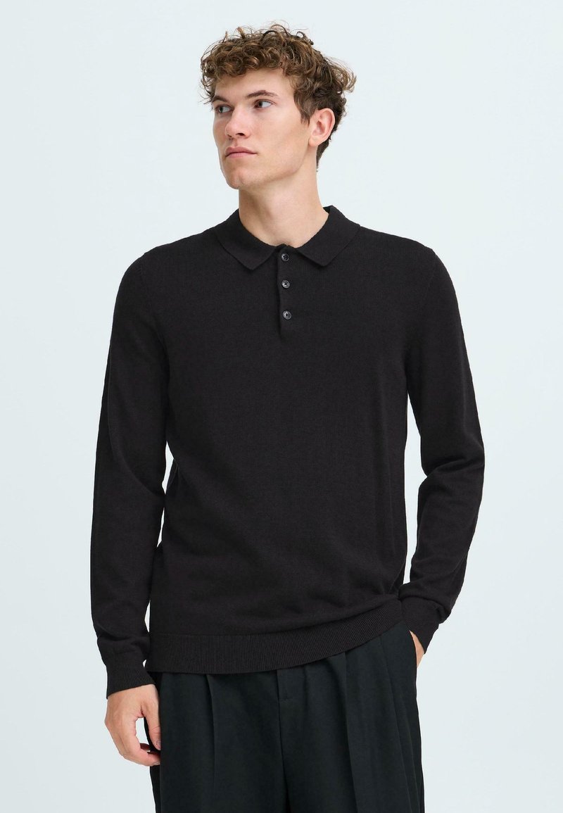 Črna dolge rokave polo majica, pleten material, običajen kroj, tri gumbe na zapenjanju, rebrasti manšeti in rob, gladka tekstura.