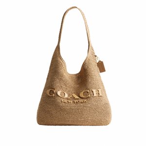 Tan gekleurde geweven schoudertas met een enkele riem en groot verhoogd "COACH New York" logo aan de voorkant, voorzien van een klein hangend label.