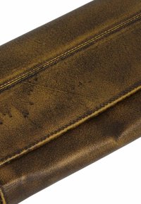 Cartera de cuero marrón con superficie texturizada, costuras cosidas y cierre con solapa. Muestra un aspecto desgastado y rústico, con variaciones de color.
