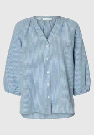 Blouse bleu clair à rayures verticales blanches, avec encolure froncée, boutonnage avant et manches bouffantes 3/4 avec poignets élastiqués.