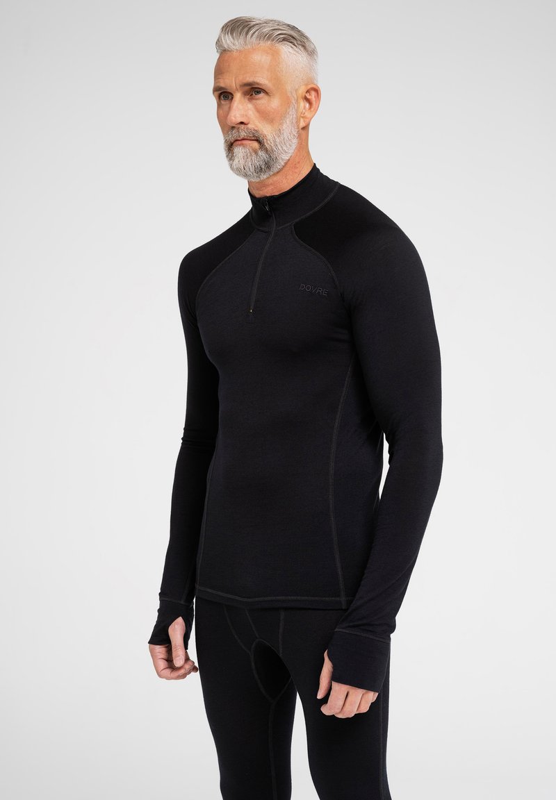 Schwarzes Langarm-Baselayer mit halbem Reißverschluss, mit kontrastierenden Nahtdetails und Daumenöffnungen. weicher, dehnbarer Stoff.