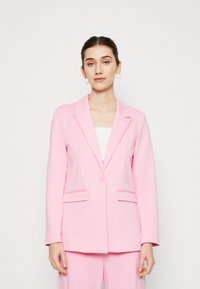 Blazer ajusté rose avec une fermeture à un bouton, des revers en notches et deux poches avant. Fabriqué en tissu lisse avec une coupe structurée.