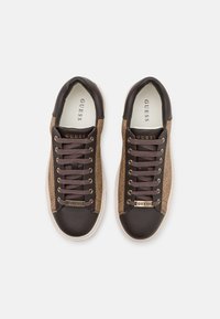 Baskets en cuir marron et foncé avec des détails en métal doré, bout arrondi et design à lacets. Panneaux latéraux texturés et semelles intérieures rembourrées.