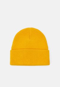 Gul strikket hue med ribbet struktur og en foldet kant. Taperet top med sømløs design. Blødt materiale egnet til varme.