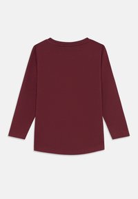 Camisa longa de mangas burgundy sólida com decote redondo, vista por trás sobre um fundo branco.