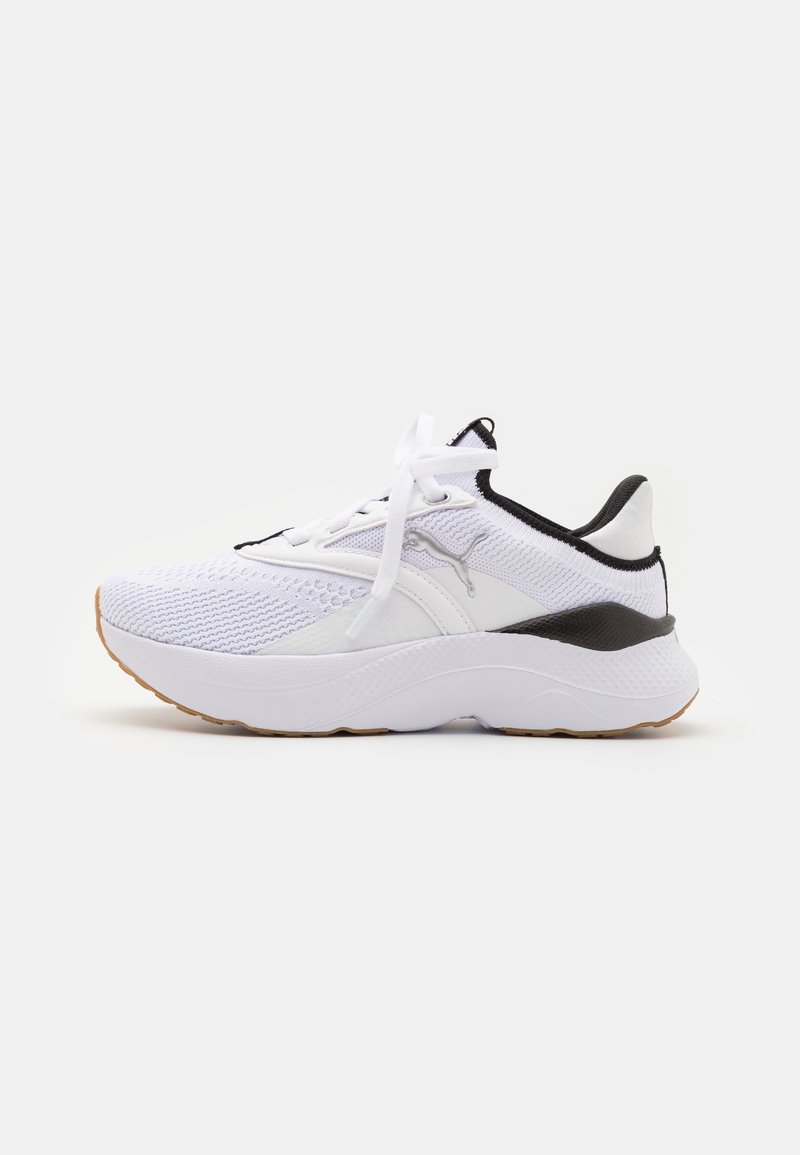 Witte sportieve schoen met een bovenwerk van mesh, zwarte accenten en een gewatteerde zool. Heeft veters en een logo aan de zijkant, met een textuurdesign voor ademend vermogen.