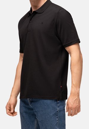 Zwart polo shirt van gestructureerde stof, met een drieknoopsluiting en een klein logo op de linkerborst. Klassieke pasvorm met korte mouwen.