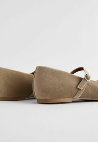 Kerged suede-plätud madala kontsaga, millel on Mary Jane rihm ja hõbedane DIY detail, siledat tekstuuri ja ümar varvaste disain.