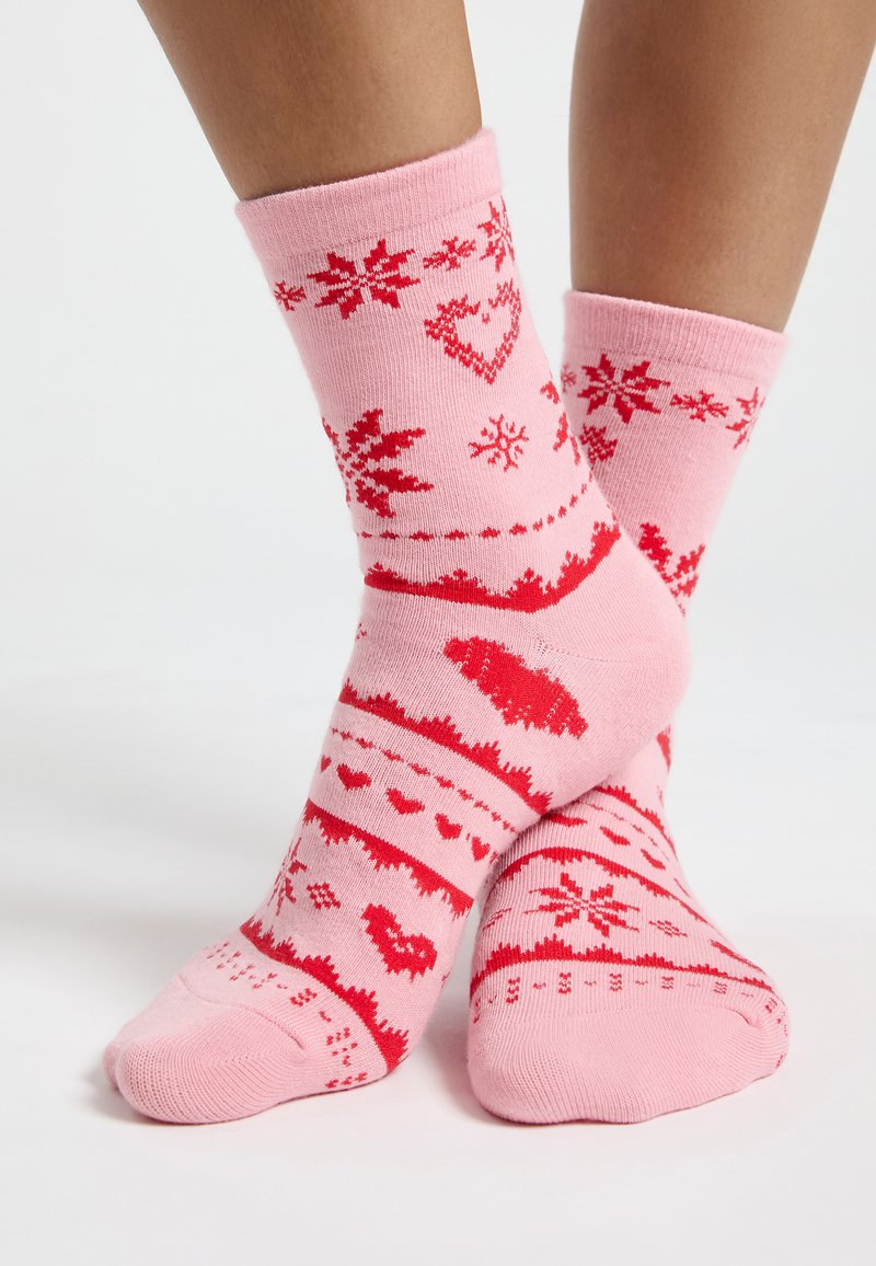 Calcetines de algodón rosa con patrones festivos rojos, incluidos corazones y copos de nieve, con puños acanalados y una textura suave.