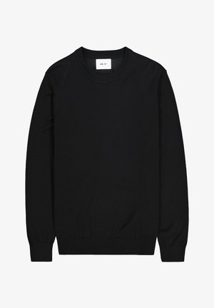 Svart stickad tröja med rund halsringning, långa ärmar, ribbade muddar och nederkant. Etikett med "NN. 07" synlig på halsen.