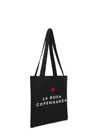 Borsa a tracolla nera in tessuto con due manici in raso, decorata con un accento di rosa rossa e la scritta "LA ROSA COPENHAGEN" in bianco.