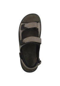 Ruskea ja musta avonainen sandaali, jossa on kaksi säädettävää Velcro-nauhaa, pehmustettu pohja ja tekstuuripohja pidon parantamiseksi.