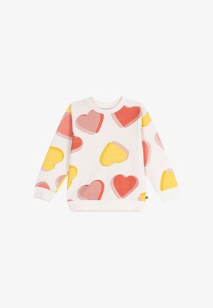 Witte trui met lange mouwen met grote roze, rode en gele hartpatronen verspreid over de stof.